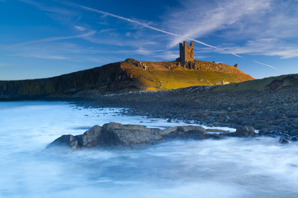 England, Northumberland, Embleton Bay. Last light on The Lilburn Tower, part of the remains of Dunstanburgh Castle, viewed from Embleton Bay.