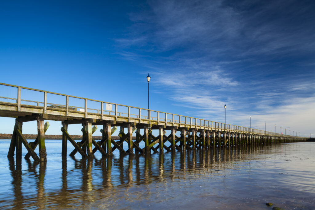 England, Northumberland, Amble. Amble Pier running alonside Amble Harbour on the North Sea Coast.