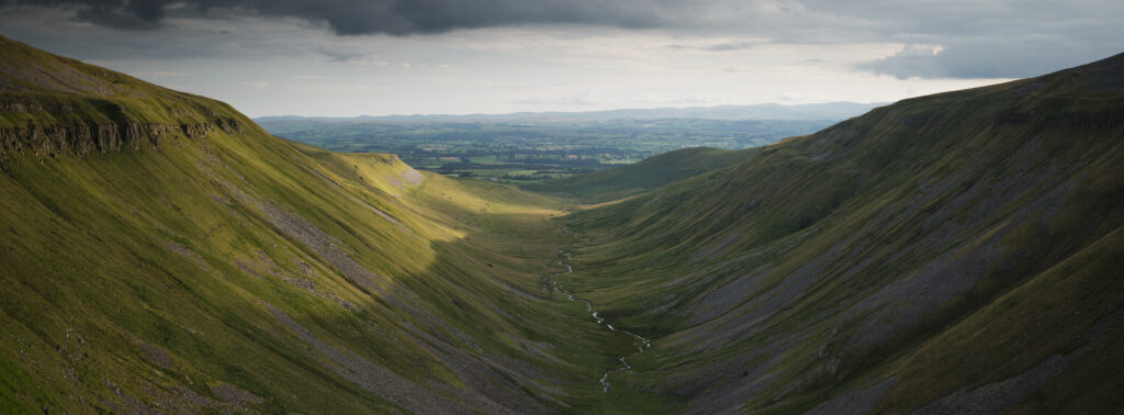 England, Cumbria, High Cup Nick. High Cup Gill — also known as High Cup Nick — is a strikingly symmetrical U-shaped valley carved deep into the Pennine escarpment near Appleby-in-Westmorland, Cumbria, within the North Pennines Area of Outstanding Natural Beauty.