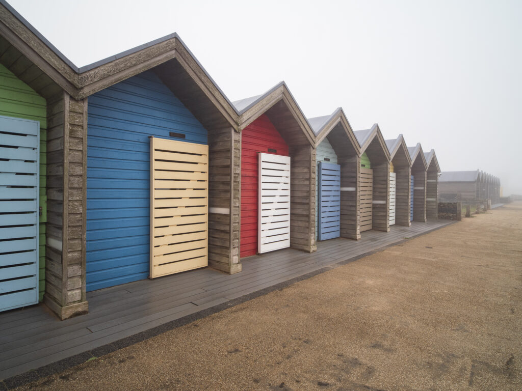England, Northumberland, Blyth. Colourful Beach Huts located on South Blyth Sea Front, photographed on a foggy morning.