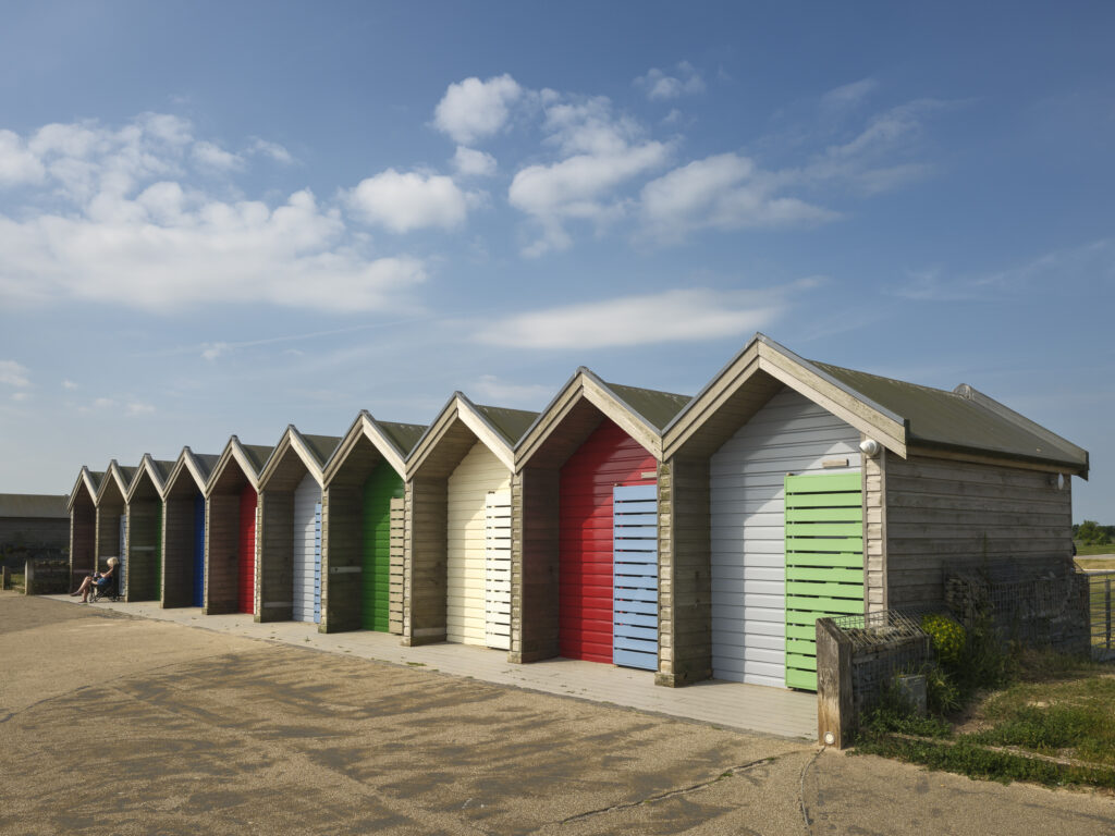 England, Northumberland, Blyth. Freshly painted colourful beach huts on the promenade at Blyth Beach.